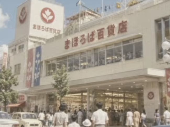 まほろば百貨店CMの実映像。建物の前を買い物客が行き交う